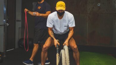 man in white crew neck t shirt doing training using ropes