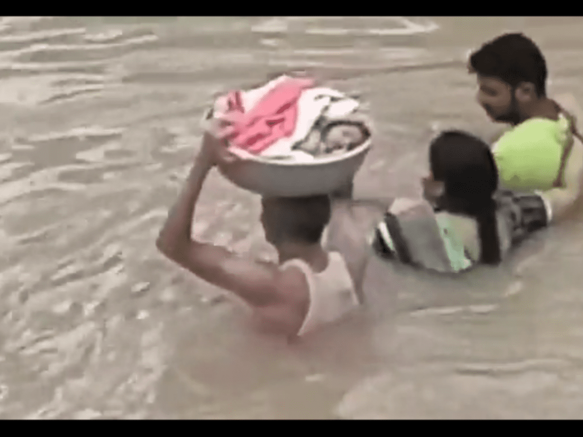 A toddler was rescued on a plastic tub carried on the head by a rescue worker