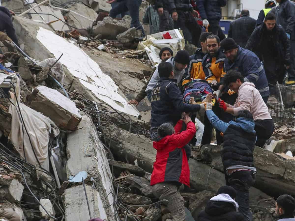 People and emergency teams rescue a person on a stretcher from a collapsed building in Adana, Turkey, Monday, Feb. 6, 2023. (Photo: AP)