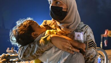 Saudi woman soldier who embraces sleeping toddler during Sudan evacuee wins praise