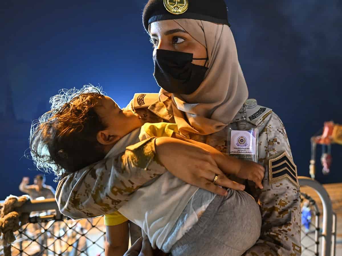 Saudi woman soldier who embraces sleeping toddler during Sudan evacuee wins praise