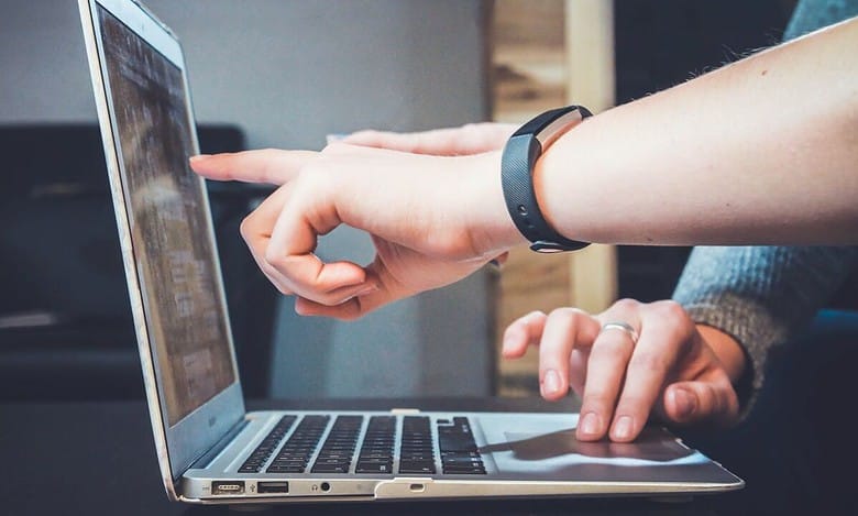 Representation Image of people pointing at a laptop screen for JEE main results
