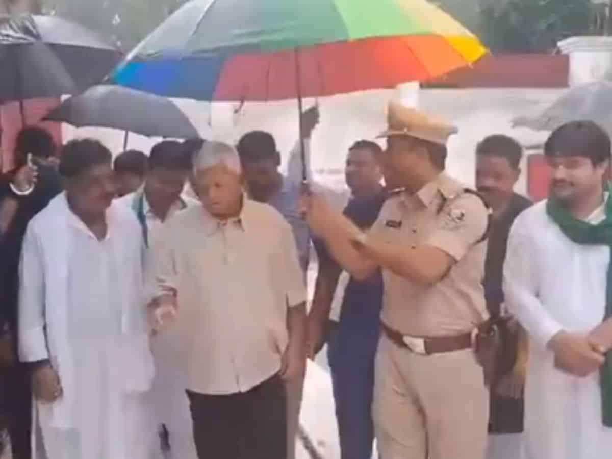 Sub-Divisional Police Officer (SDPO) of Gopalganj district held an umbrella for Lalu Prasad Yadav