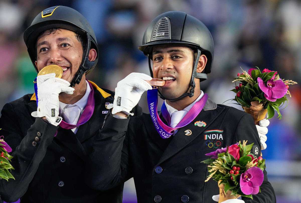 Indias bronze medalist Anush Agarwalla (Etro) stands at the podium with Malaysia's gold medalist Bin Mahamad Fathil Mohd Qabil Ambak after the Equestrian Dressage Individual Final event at the 19th Asian Games, in Hangzhou, China, Thursday, Sept. 28, 2023. (PTI Photo/Gurinder Osan)