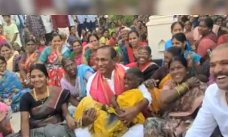 Minister Malla Reddy lifted an elderly woman in his arms.