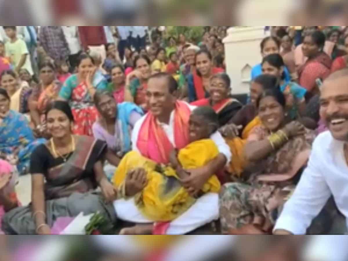 Minister Malla Reddy lifted an elderly woman in his arms.