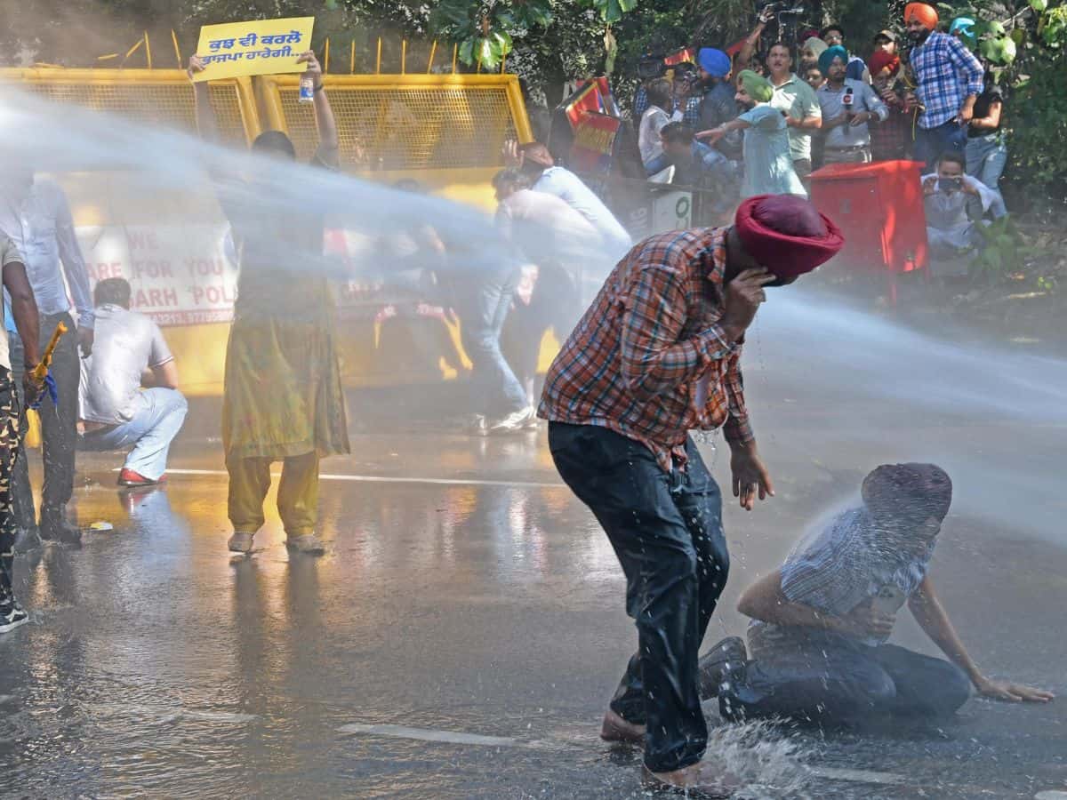 Police use water cannon to disperse AAP workers protesting against the arrest of party leader Sanjay Singh