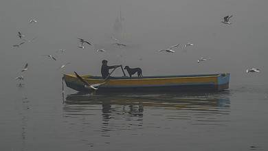 New Delhi: A man rides his boat on the Yamuna river on a hazy winter morning, in New Delhi, Sunday, Nov. 26, 2023. (PTI Photo/Manvender Vashist Lav)(PTI11_26_2023_000058B)