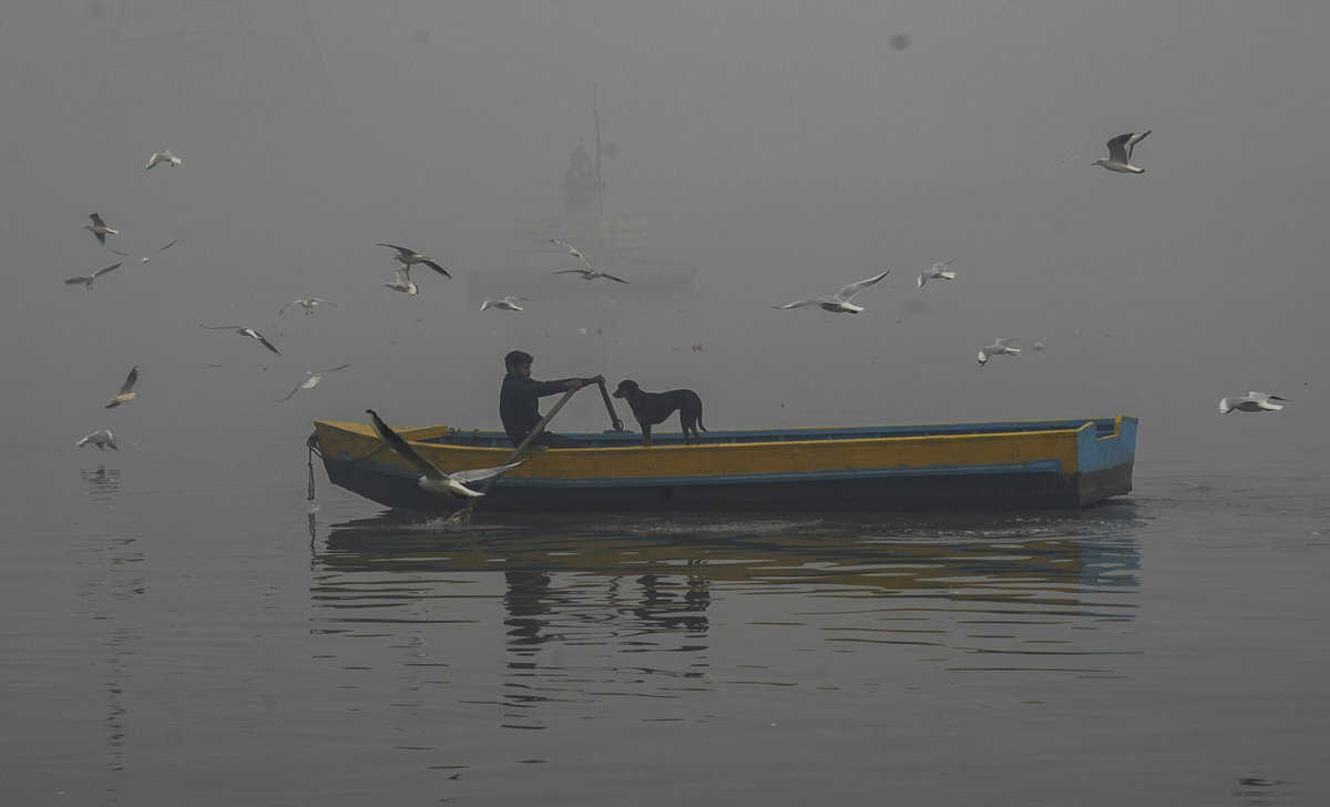 New Delhi: A man rides his boat on the Yamuna river on a hazy winter morning, in New Delhi, Sunday, Nov. 26, 2023. (PTI Photo/Manvender Vashist Lav)(PTI11_26_2023_000058B)