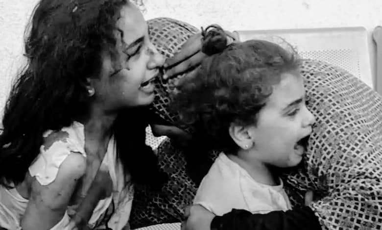 A Palestinian woman comforts her children as they wait at the hospital in Gaza (Photo AFP)