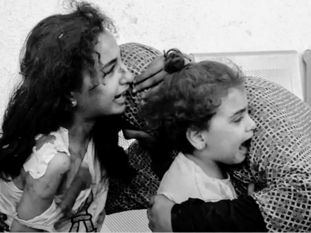 A Palestinian woman comforts her children as they wait at the hospital in Gaza (Photo AFP)
