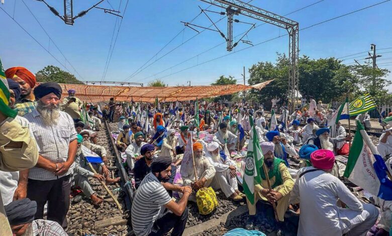 Farmers sit on railway tracks during a protest at the Shambhu border, in Patiala district,