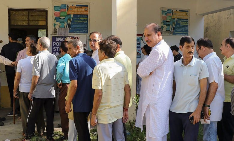 Jammu Kashmiri Pandits stand in a queue to cast their vote