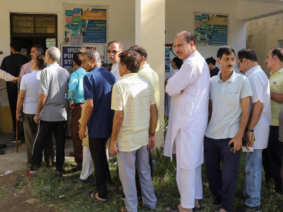 Jammu Kashmiri Pandits stand in a queue to cast their vote