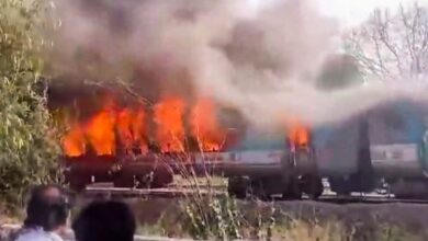 A firefighter inside a charred coach of the Taj Express after a fire broke out in the train