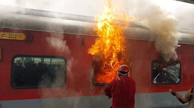 train fire A firefighter tries to douse a fire that broke out in the Tirumala Express at Visakhapatnam railway station, Sunday, Aug. 4, 2024. (PTI Photo)