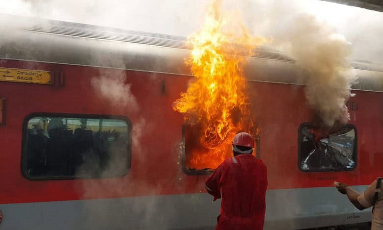 train fire A firefighter tries to douse a fire that broke out in the Tirumala Express at Visakhapatnam railway station, Sunday, Aug. 4, 2024. (PTI Photo)