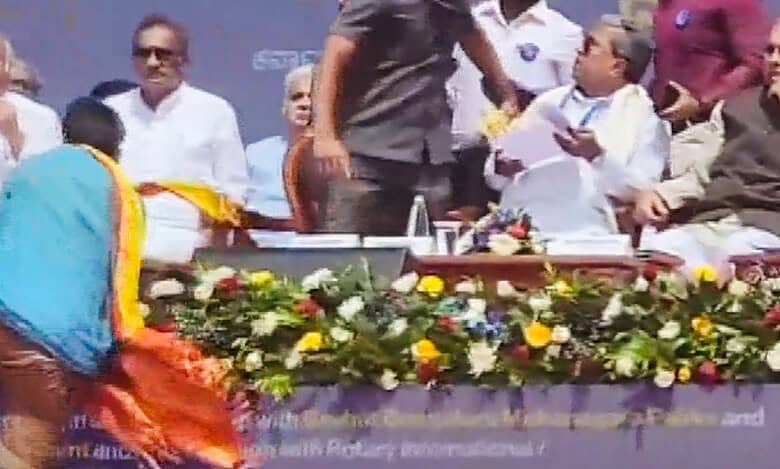 An unidentified person approaches Karnataka CM Siddaramaiah's chair