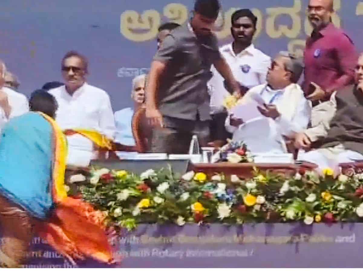 An unidentified person approaches Karnataka CM Siddaramaiah's chair
