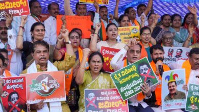 A BJP worker holds a placard during a protest against the Congress government in Karnataka over the Waqf land issue, in Bengaluru, Friday, Nov. 22, 2024. (PTI Photo