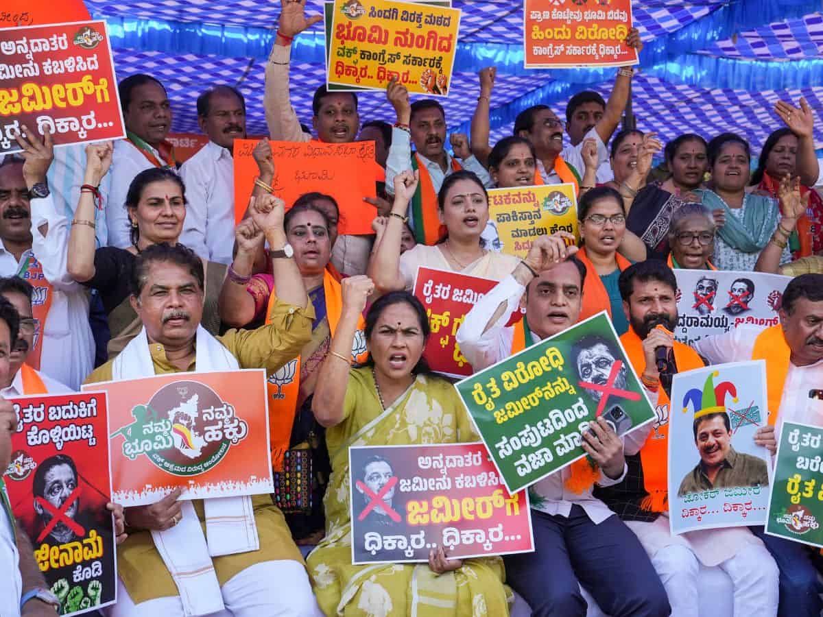 A BJP worker holds a placard during a protest against the Congress government in Karnataka over the Waqf land issue, in Bengaluru, Friday, Nov. 22, 2024. (PTI Photo