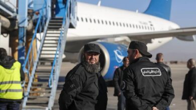 General Security personnel stand next to a Syrian Air airplane ahead of take-off as the airport reopens for internal flights in Damascus on Wednesday, December 18.