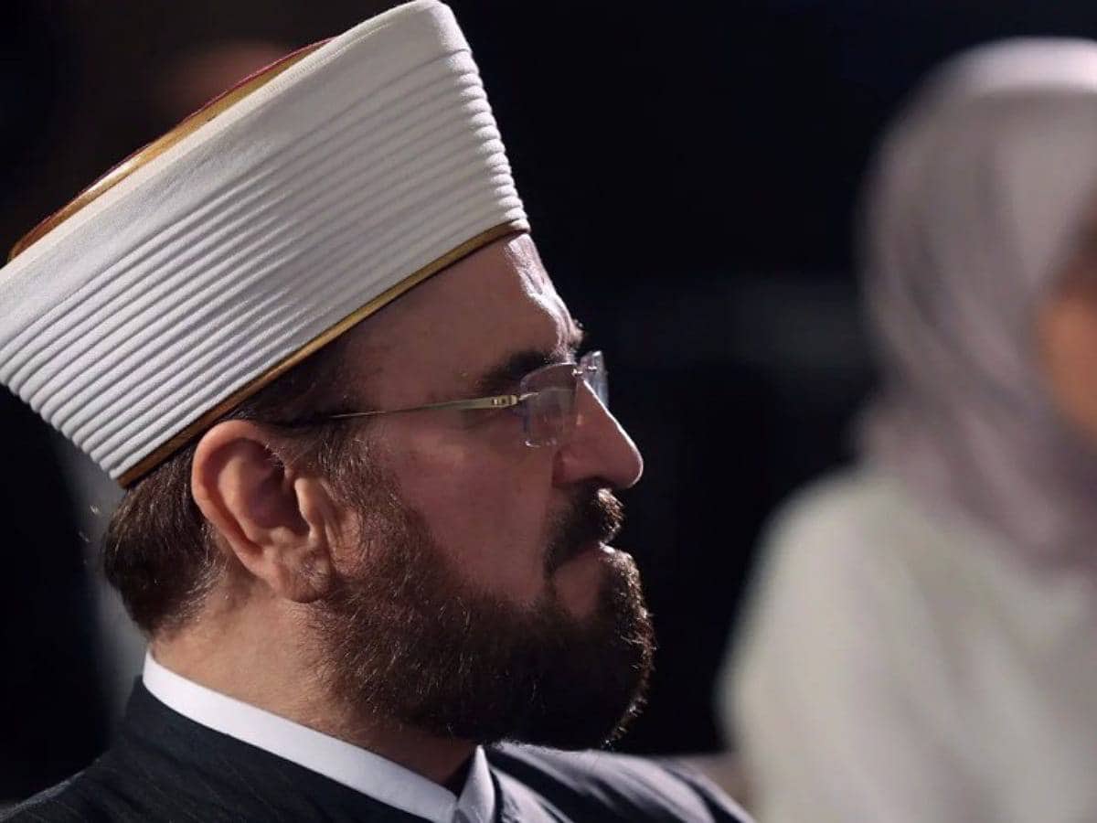 Ali AlQaradaghi, Secretary-General of the International Union of Muslim Scholars (IUMS), wearing traditional Islamic attire and a white turban, captured in a side profile during a formal event or conference.