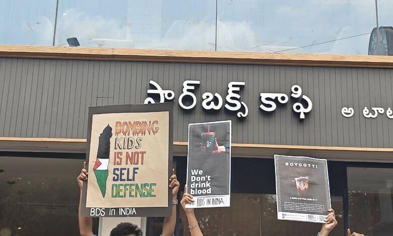 Protesters hold signs outside Starbucks in Hyderabad, supporting BDS against Israel, with "Bombing kids is not self-defense" and "We don't drink blood" messages.