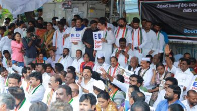 Telangana Congress leaders sitting in protest outside the Enforcement Directorate (ED) office in Hyderabad, holding placards and raising slogans.