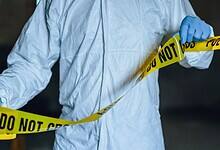 Representational Image of man putting up the crime scene tape