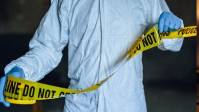 Representational Image of man putting up the crime scene tape