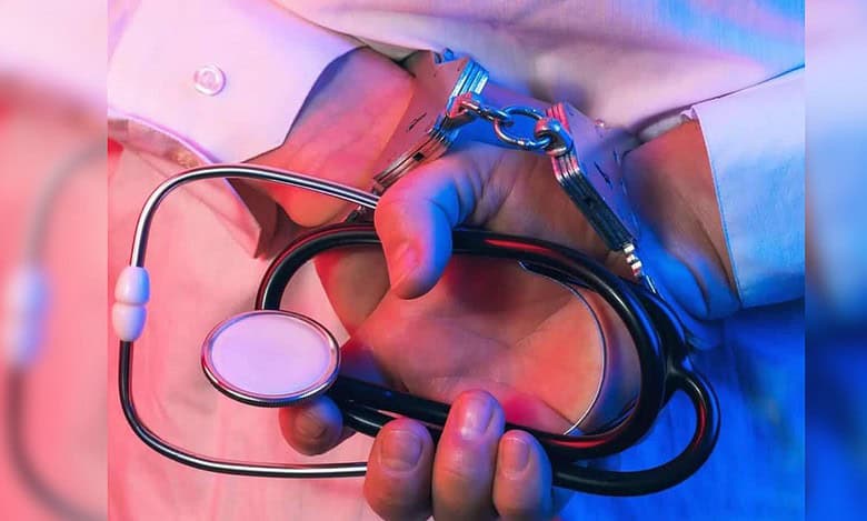 Handcuffed person holding a stethoscope, symbolising arrest of a fake doctor or medical fraud at Hyderabad hospital