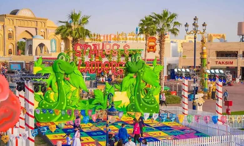 Colourful Snakes and Ladders-themed play area at Global Village Dubai with giant green snake figures, vibrant game board, and visitors enjoying family-friendly activities.