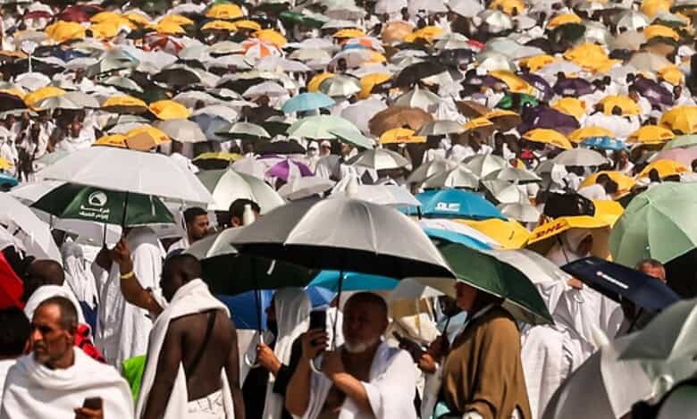 A large crowd of Haj pilgrims in white ihram garments use colourful umbrellas to shield themselves from the intense summer heat in Makkah, Saudi Arabia, during the annual pilgrimage.