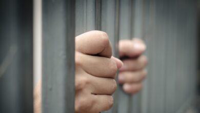 Representational Image of man holding prison bars