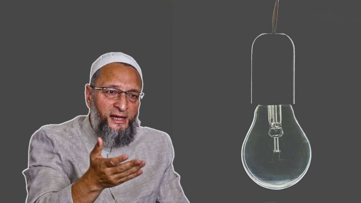 Asaduddin Owaisi wearing a light gray traditional outfit and white cap gestures with their hands against a dark background. To the right, a large, unlit light bulb is depicted.