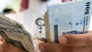 Representative image shows man counting Saudi riyal banknotes.