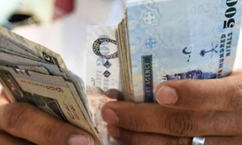 Representative image shows man counting Saudi riyal banknotes.