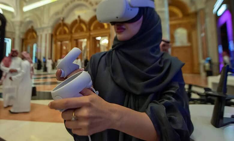 Saudi woman wearing VR headset and using controllers at a tech event in Riyadh