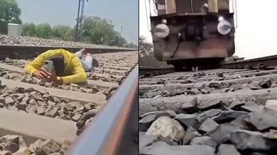 There are two images in this. The first image shows a young man in yellow shirt laying on a railway track with hi head down and a mobile. The second image shows an incoming train