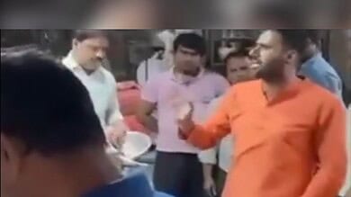 A man in saffron clad clothes talks to fish sellers in East Delhi on April 9, 2025