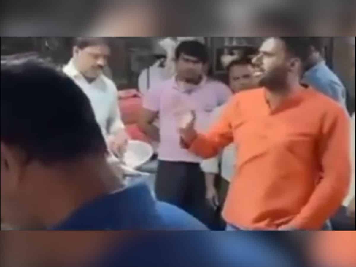 A man in saffron clad clothes talks to fish sellers in East Delhi on April 9, 2025