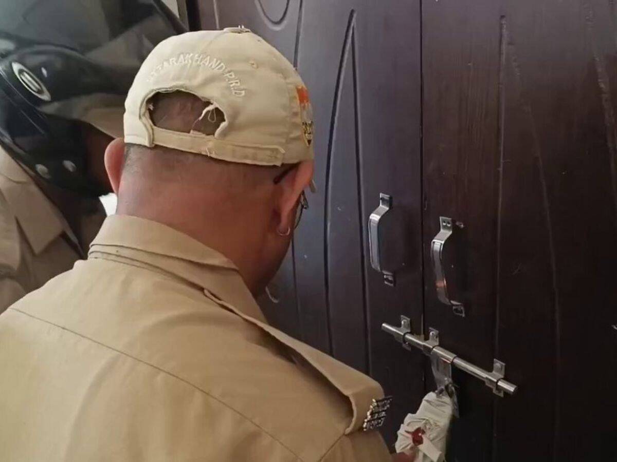 The image displays police officials sealing madrasa in Uttarakhand's Haldwani district on Sunday. April 13, 2025