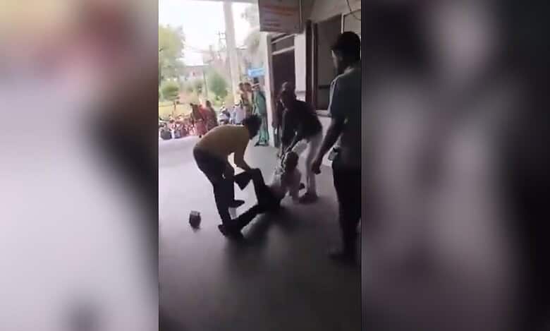 The image displays a senior citizen being dragged by a few men in a district hospital in Madhya Pradesh