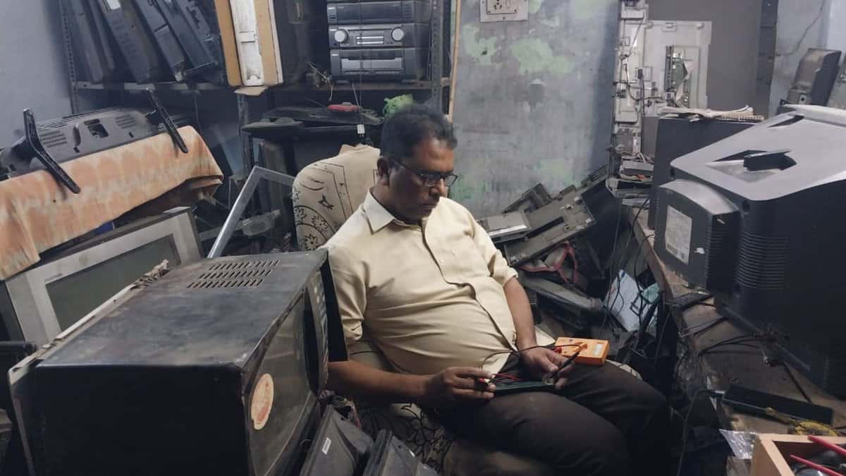 The image displays a picture of a man named Mohd Abdul Ishaq repairing old television sets in Hyderabad. April 26, 2025