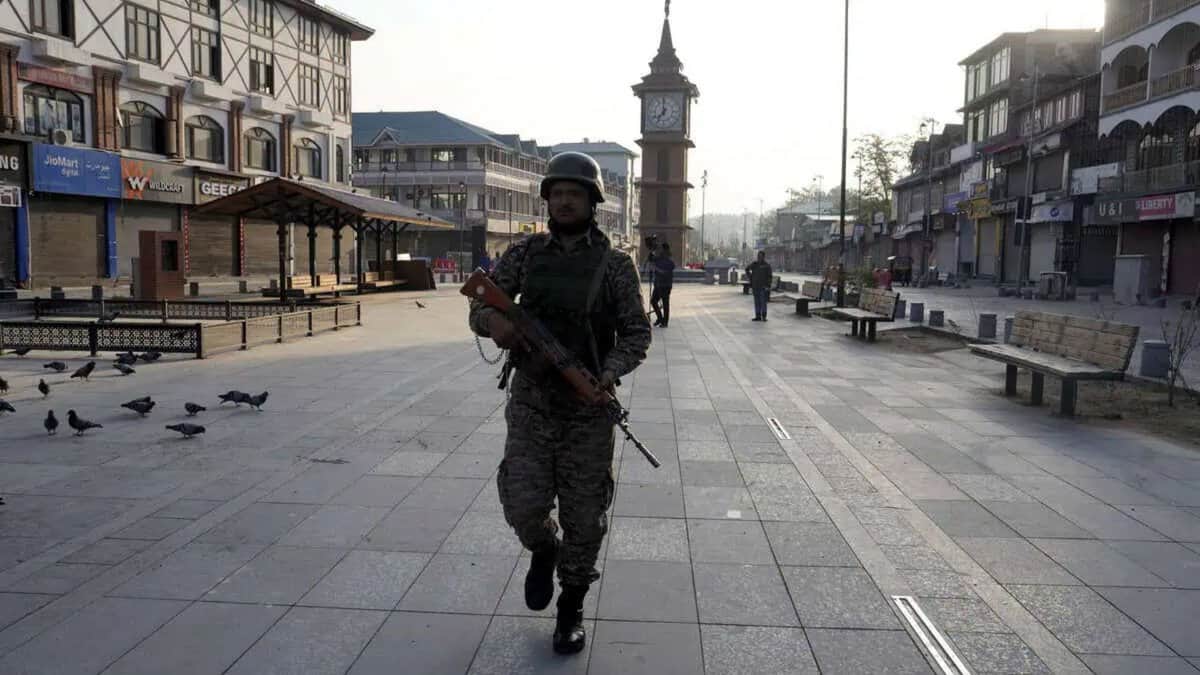 The image displays a picture of a security personnel standing guard at Lal Chowk market
