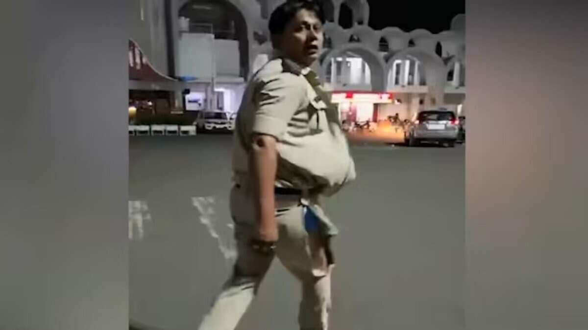 The image displays a picture of a GRP officer with his uniform ripped off from a scuffle in Bhopal