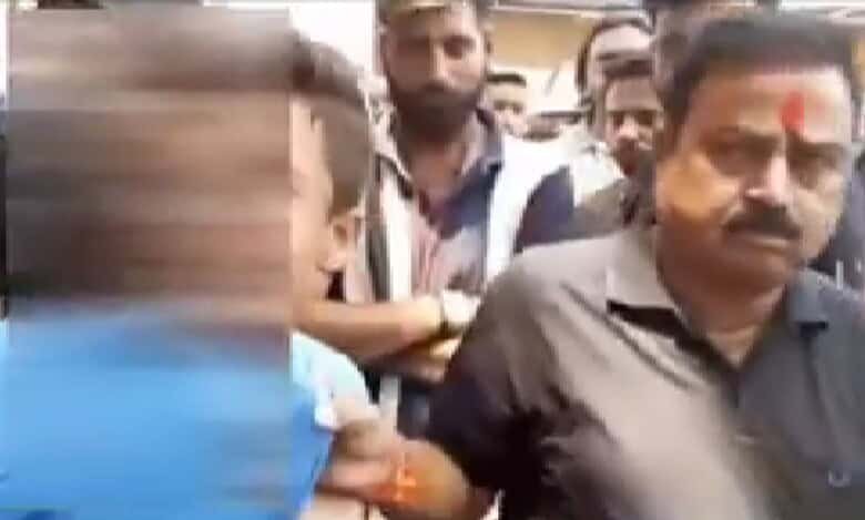 The image displays a blurred picture of a teenager being whisked away by a man who has a saffron tikal on his forehead in Aligharh.