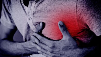 Representational image of a man clutching his chest and collapsing on a cricket field due to cardiac arrest.