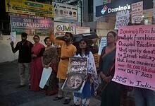 A group of protesters on May 10 stand outside a Domino’s outlet in India, holding signs in solidarity with Palestine. One sign reads, "Slice of Genocide?"
